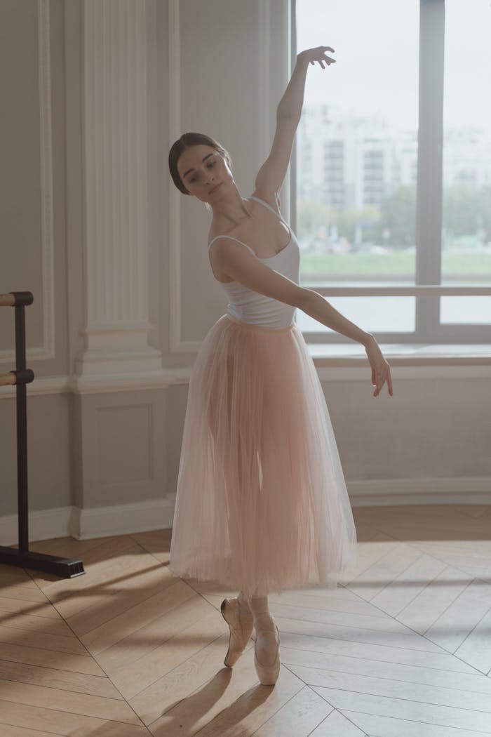 A ballerina elegantly poised in a soft-lit dance studio, showcasing grace and skill.